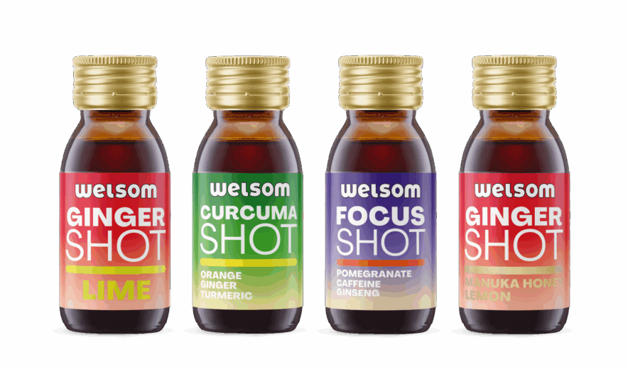 Four functional Welsom shots in glass bottles: Ginger Lime, Curcuma Orange Ginger Turmeric, Focus Pomegranate Caffeine Ginseng, Ginger Manuka Honey Lemon