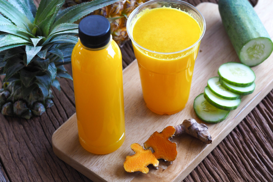 Turmeric and pineapple wellness shot with cucumber – natural detox juice in bottle and glass