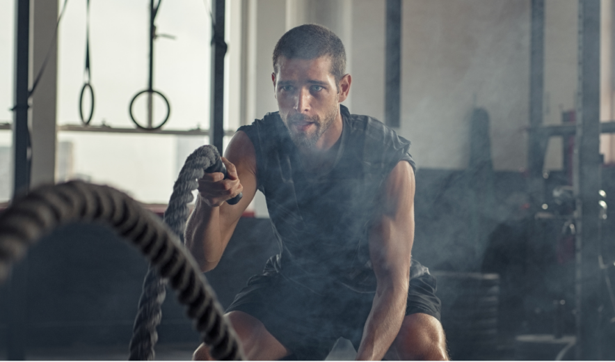 Focused man training with battle ropes – natural energy boost for intense workouts