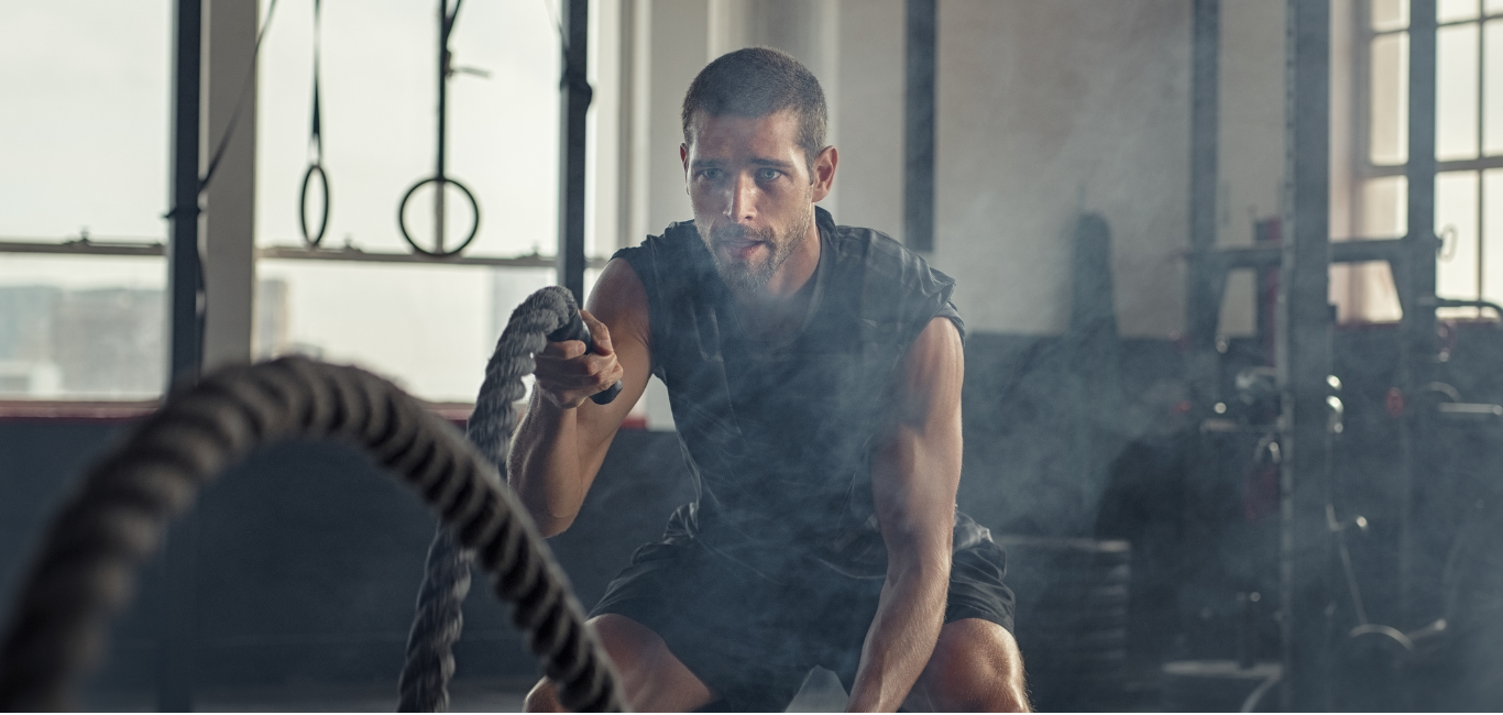 Focused man training with battle ropes – natural energy boost for intense workouts