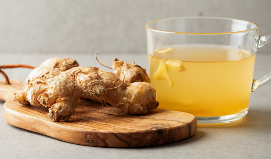 Glass cup of ginger tea with fresh ginger – key ingredient in ginger shots for digestion and energy