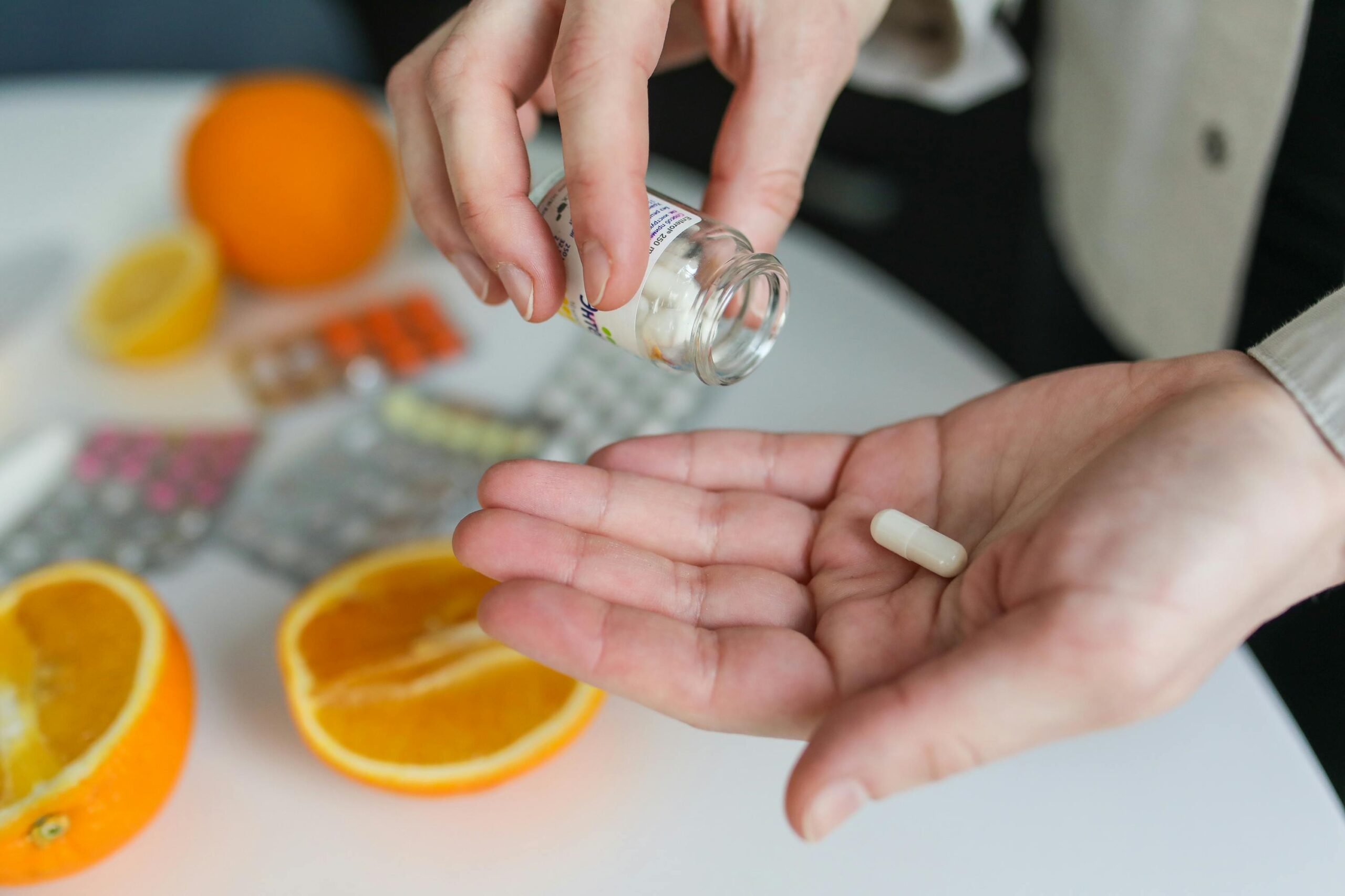 Taking a dietary supplement capsule – natural vitamin boost with citrus in the background